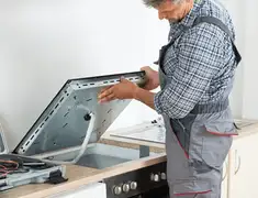 Appliance repair technician installing a built-in cooktop in Little Rock, AR