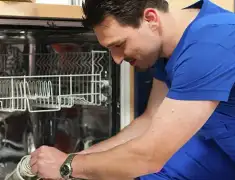 Dishwasher repair technician inspecting and servicing an open dishwasher in Little Rock, AR
