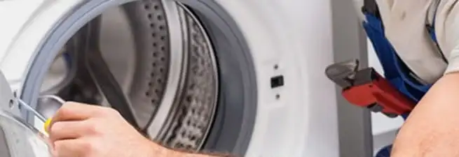 Appliance technician repairing a clothes dryer drum and internal parts in Little Rock, AR