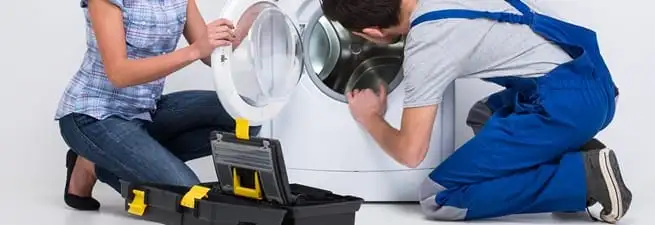 Washer repair technician inspecting a front-load washing machine with tools in Little Rock, AR