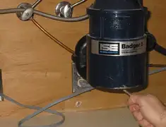 Garbage disposal repair technician tightening the mounting ring under a sink in Little Rock, AR