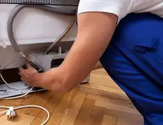 Appliance repair technician fixing refrigerator water line and connections in Little Rock, AR