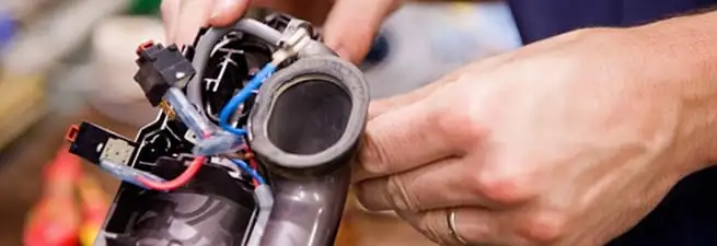 Vacuum repair technician reconnecting wiring and components in Little Rock, AR
