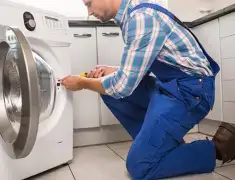 Washing machine repair technician servicing a front-load washer in Little Rock, AR