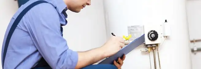 Water heater repair technician inspecting the unit and recording service notes in Little Rock, AR
