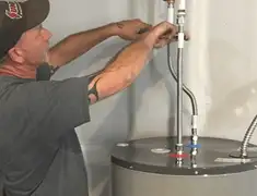 Water heater repair technician tightening supply line connections in Little Rock, AR