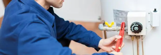 Water heater repair technician adjusting the temperature control and gas valve in Little Rock, AR
